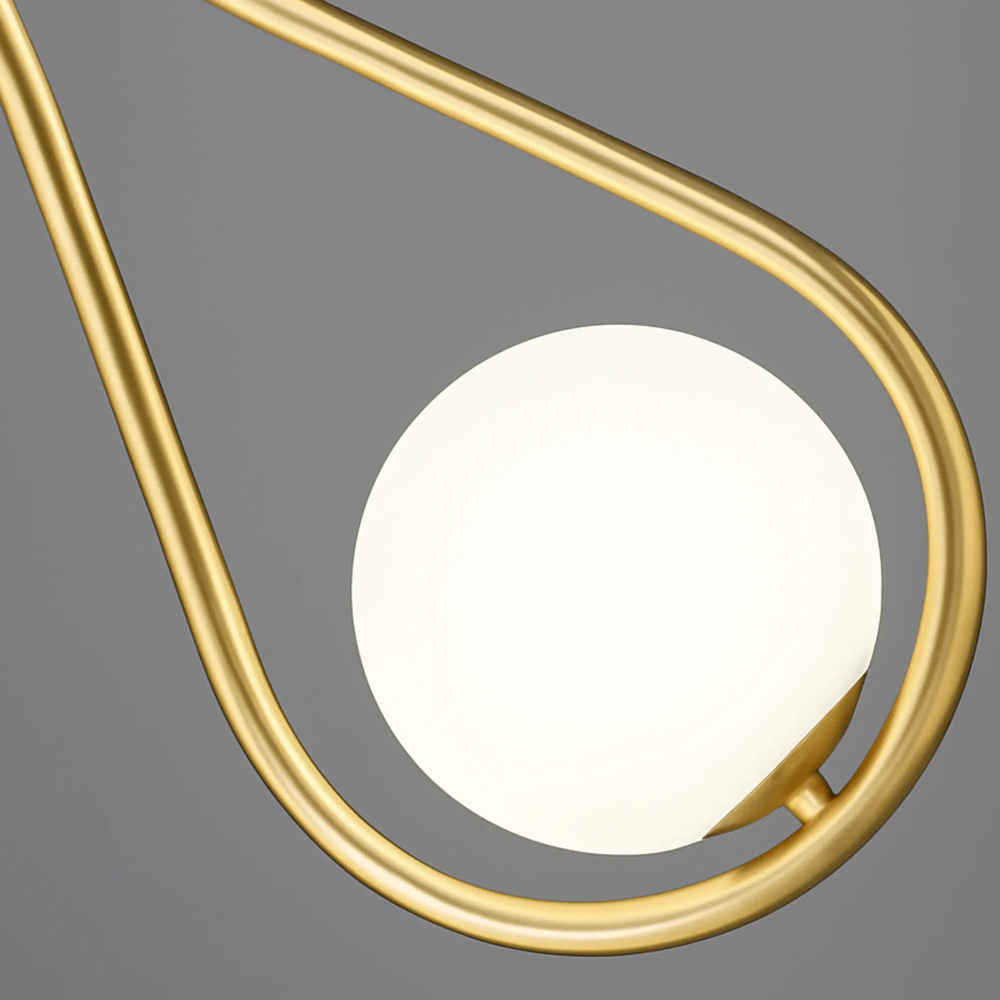 Applique murale dorée à bras arrondi avec globe lumineux et interrupteur intégré.